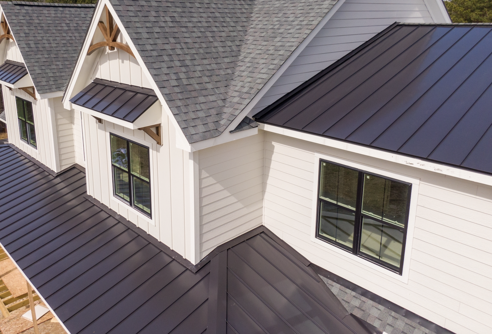 Modern home with dark metal roofing and gray shingles highlighting its pros and cons.