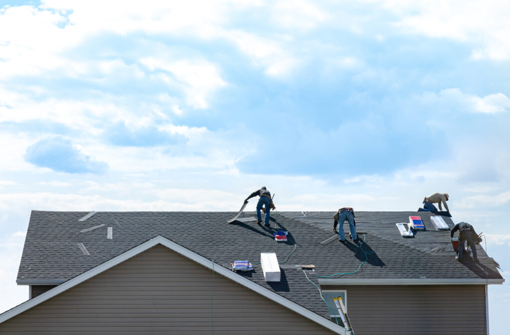Salty Dog Roofing crew performing winter roof repairs on a residential home, replacing shingles during cool South Carolina weather